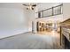 Open living room with fireplace, high ceilings, and a view into the kitchen and the home's upper level at 13515 Milwaukee Ct, Thornton, CO 80241
