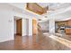Spacious living room with hardwood floors, an open staircase, modern lighting, and a view of the adjacent updated kitchen at 3948 S Halifax St, Aurora, CO 80013