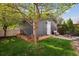 Charming backyard with a lush lawn, mature tree, and cozy fire pit area at 2857 Xanthia Ct, Denver, CO 80238