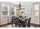 A naturally lit dining room with a dark wood table, chandelier, and neutral decor at 2857 Xanthia Ct, Denver, CO 80238