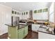 Well-lit kitchen features stainless steel appliances, granite countertops, and stylish green island at 2857 Xanthia Ct, Denver, CO 80238