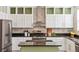 Modern kitchen with white cabinets, a stainless steel range hood, and black countertops at 2857 Xanthia Ct, Denver, CO 80238