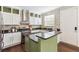 Well-lit kitchen features stainless steel appliances, granite countertops, and stylish green island at 2857 Xanthia Ct, Denver, CO 80238