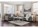 Comfortable living room showcasing dark hardwood floors, neutral decor, and ample natural light through large windows at 2857 Xanthia Ct, Denver, CO 80238
