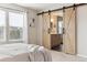Main bedroom leading to ensuite bathroom, featuring barn door and large window at 2857 Xanthia Ct, Denver, CO 80238