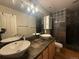 Bathroom featuring double sinks, tile countertops and a glass block shower at 1555 California St # 609, Denver, CO 80202