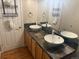 Bathroom featuring double sinks, decorative backsplash, large mirror, and modern fixtures at 1555 California St # 609, Denver, CO 80202