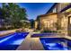 Backyard pool and patio area with lounge chairs, umbrella, and lush landscaping under evening lights at 2821 E Cedar Ave # 14, Denver, CO 80209