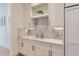 Wet bar featuring white cabinets, marble countertops and backsplash with brass hardware at 2821 E Cedar Ave # 14, Denver, CO 80209