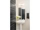 Stylish powder room features a pedestal sink, modern fixtures, and a decorative mirror at 3198 Blake St # 402, Denver, CO 80205