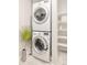 Modern, stacked washer and dryer unit with bright white shelving, perfect for efficient laundry space organization at 3198 Blake St # 402, Denver, CO 80205