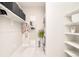 Bright laundry room featuring white washer/dryer, shelving, mirror, and storage, offering functionality and style at 3198 Blake St # 402, Denver, CO 80205