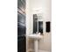 Stylish powder room featuring a pedestal sink, sleek black door, and modern fixtures at 3198 Blake St # 402, Denver, CO 80205