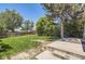 A spacious, grassy backyard is bordered by a wood fence and mature trees, with a small patio area at 4111 S Delaware St, Englewood, CO 80110