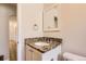 Updated bathroom with granite countertop vanity, stylish mirror, and neutral wall paint at 4111 S Delaware St, Englewood, CO 80110
