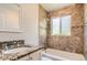 Bathroom featuring granite countertop vanity, mirror, and tiled shower and tub at 4111 S Delaware St, Englewood, CO 80110