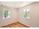 Bedroom featuring wood flooring, neutral paint, and natural light from two windows at 4111 S Delaware St, Englewood, CO 80110