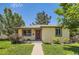 Charming home with mature trees, green lawn, and a vibrant red front door at 4111 S Delaware St, Englewood, CO 80110