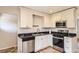 Well-lit kitchen featuring modern stainless steel appliances and white cabinets at 4111 S Delaware St, Englewood, CO 80110