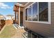 Backyard of the home with a covered porch, large window, and a wooden fence bordering the lawn at 11482 Colony Loop, Parker, CO 80138