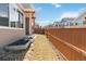 Image shows the length of the backyard with the tall fence, the side of the home, and the egress window at 11482 Colony Loop, Parker, CO 80138