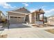 Traditional home featuring a two-car garage and a covered porch with stone veneer at 11482 Colony Loop, Parker, CO 80138