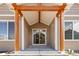 Inviting front entrance features a covered porch with decorative wood columns and a glass sliding front door at 11482 Colony Loop, Parker, CO 80138