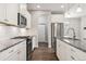 Bright kitchen showcasing white cabinets, granite countertops, stainless steel appliances and hardwood floors at 11482 Colony Loop, Parker, CO 80138