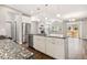 Open-concept kitchen island featuring white cabinets, stainless steel appliances, granite countertops and hardwood floors at 11482 Colony Loop, Parker, CO 80138