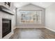Cozy living room featuring a fireplace, a large window, hardwood flooring, and plenty of natural light at 11482 Colony Loop, Parker, CO 80138