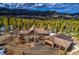 Stunning home with stone and tan siding, mountain views, and a three-car garage nestled among towering trees at 11405 Conifer Ridge Dr, Conifer, CO 80433