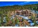 Aerial view of luxury home nestled in the mountains with surrounding trees and scenic landscape at 11405 Conifer Ridge Dr, Conifer, CO 80433