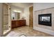 Luxurious bathroom featuring a walk-in shower, dark wood vanity, and a cozy fireplace at 11405 Conifer Ridge Dr, Conifer, CO 80433
