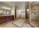Expansive primary bathroom featuring double vanity, soaking tub, walk-in shower, and travertine flooring at 11405 Conifer Ridge Dr, Conifer, CO 80433
