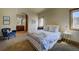 Cozy bedroom with a comfortable bed, chair, and windows offering scenic views at 11405 Conifer Ridge Dr, Conifer, CO 80433