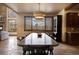 Elegant dining room with an extra-long table, view of the outdoor scenery, and natural stone flooring at 11405 Conifer Ridge Dr, Conifer, CO 80433