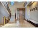 Spacious foyer with a wooden staircase, tiled flooring, a cozy bench, and a decorative wooden front door at 11405 Conifer Ridge Dr, Conifer, CO 80433