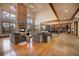 Bright and open living area with exposed beams, tall windows, a stone fireplace, and hardwood floors at 11405 Conifer Ridge Dr, Conifer, CO 80433