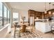 Eat-in kitchen showcasing a dining table, large windows, and wood cabinets and island at 668 Leafy Aster Ln, Castle Rock, CO 80104
