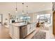 Bright kitchen showcasing a large island with stainless steel dishwasher and an adjacent dining area with fireplace at 668 Leafy Aster Ln, Castle Rock, CO 80104