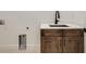 Laundry area features wood cabinets, modern faucet, and white countertops at 668 Leafy Aster Ln, Castle Rock, CO 80104