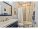 Full bathroom featuring decorative tile accent, white shower curtain, and blue vanity at 1739 E Martin Luther King Jr Blvd, Denver, CO 80205