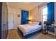 Cozy bedroom with blue curtains, a plush bed, and a functional desk area at 1739 E Martin Luther King Jr Blvd, Denver, CO 80205