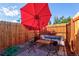 Cozy patio area with an outdoor seating set, a red umbrella, and wooden fence at 1739 E Martin Luther King Jr Blvd, Denver, CO 80205