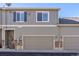 Exterior view of townhome with two-car garage and neutral siding at 4727 Raven Run, Broomfield, CO 80023
