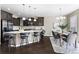 Modern kitchen with granite island, dining area, and dark cabinetry at 4727 Raven Run, Broomfield, CO 80023
