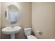 Clean bathroom with pedestal sink, toilet and oval mirror at 6792 Longpark Dr, Parker, CO 80138