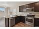 Kitchen with dark cabinets, granite counters, and stainless steel appliances at 6792 Longpark Dr, Parker, CO 80138