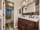 Bathroom boasts a double sink vanity with wood cabinet and decorative mosaic mirror at 9412 Burgundy Cir, Highlands Ranch, CO 80126
