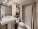 Bathroom with pedestal sink, enclosed cabinet, and shower behind curtain at 9412 Burgundy Cir, Highlands Ranch, CO 80126